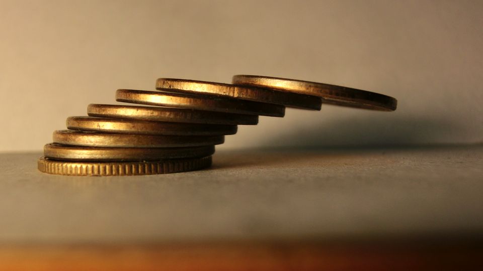 A stack of coins on a table, each coin shifted slightly further sideways than the one below it