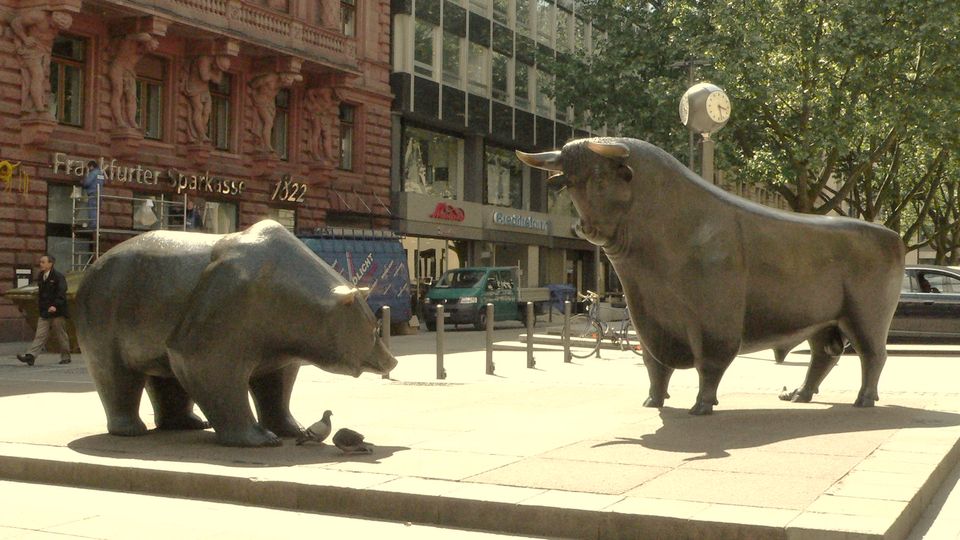 Bronze bull and bear sculptures facing each other on a city square in Frankfurt