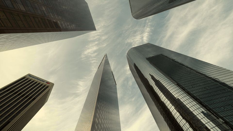 Glass skyscrapers seen from street level, looking up