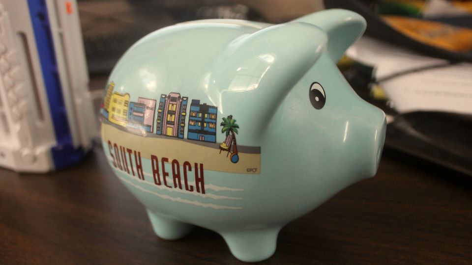 A pale blue ceramic piggy bank on a table