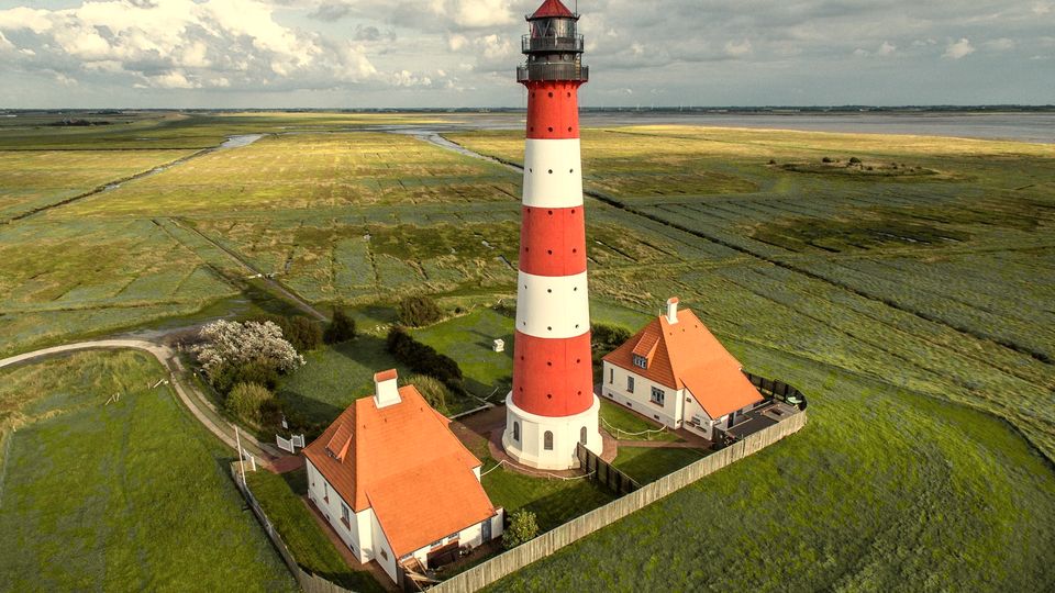 A red-and-white lighthouse standing in green fields