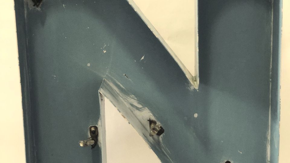 A large metal letter N on a plain background