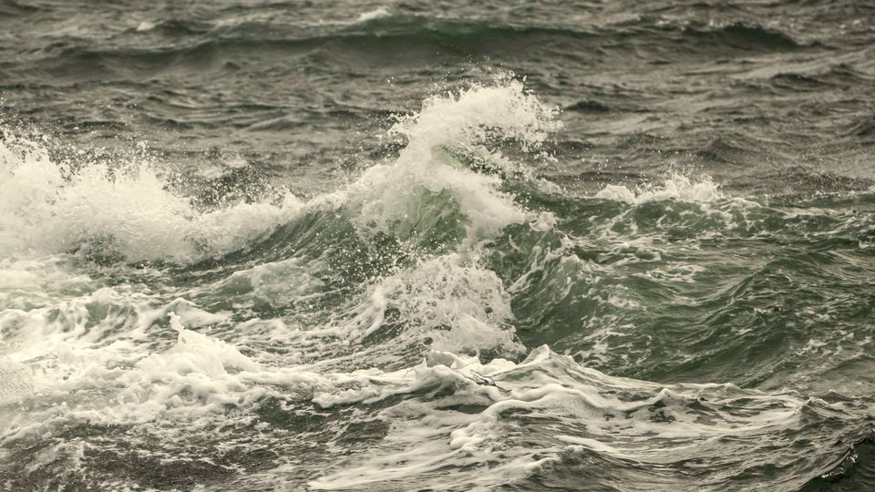 Rough grey-green sea waves breaking